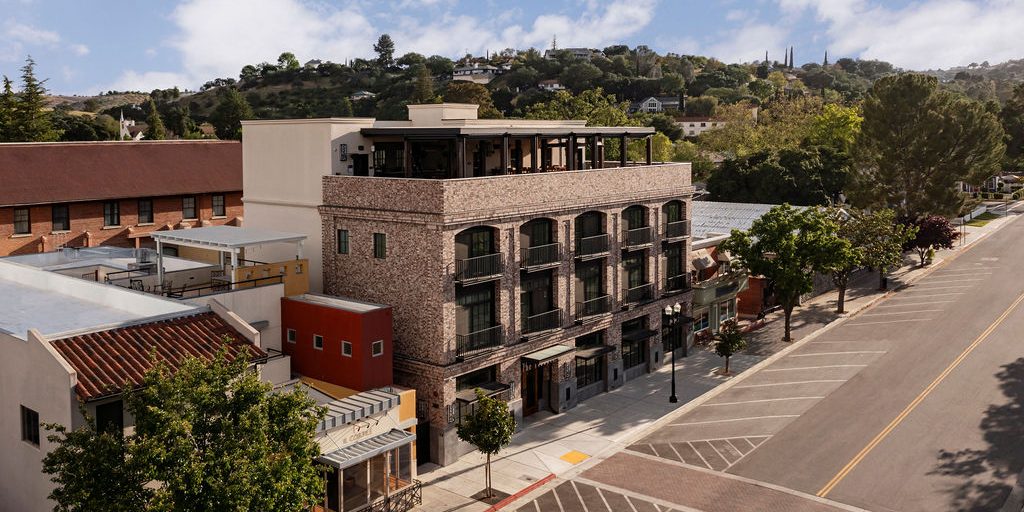 Exterior aerial view of a 3-story brick building, a sign that reads "The Piccolo" above the main entrance.