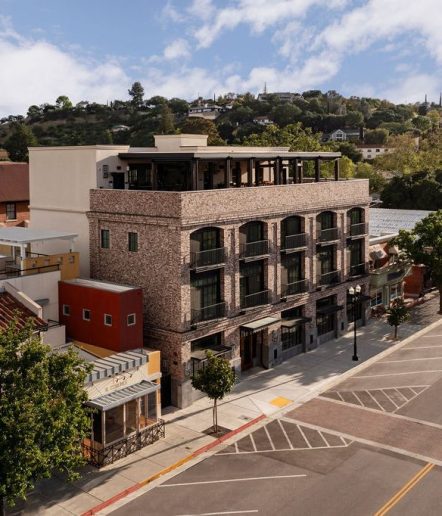 Exterior aerial view of a 3-story brick building, a sign that reads "The Piccolo" above the main entrance.