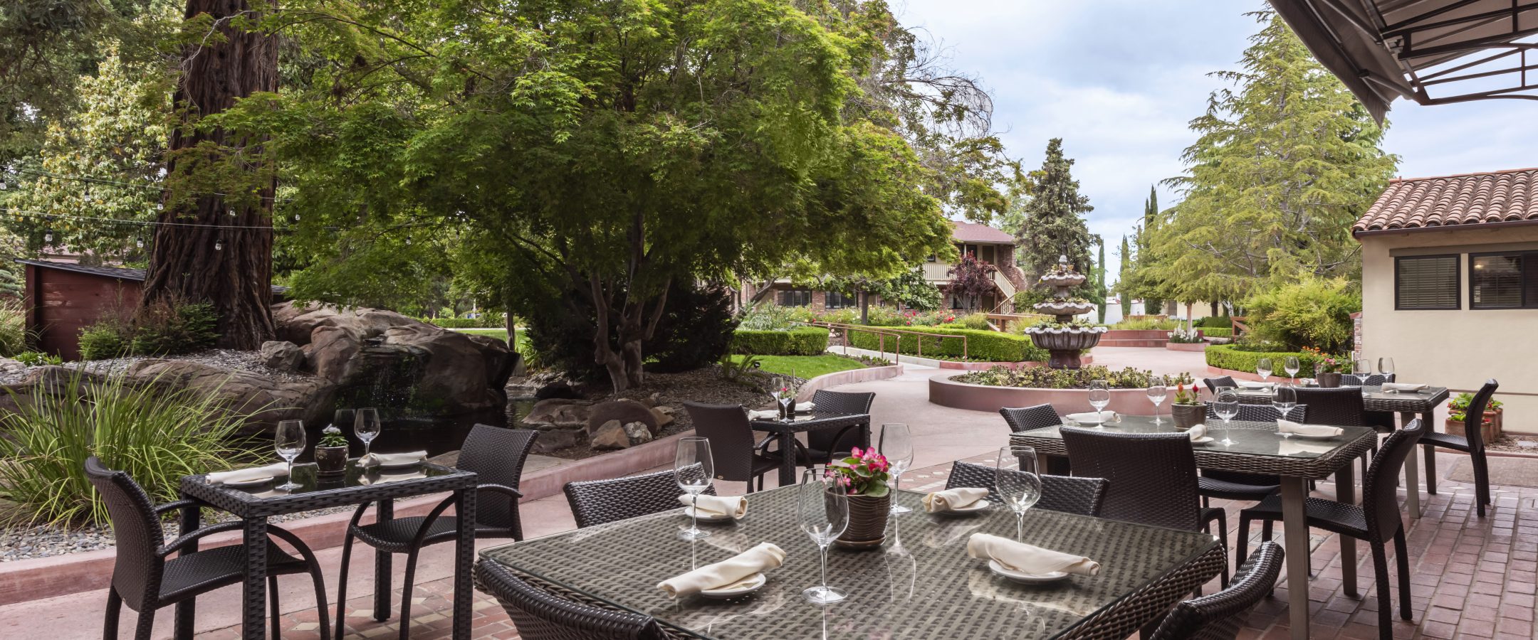 Patio dining tables in a garden setting. 