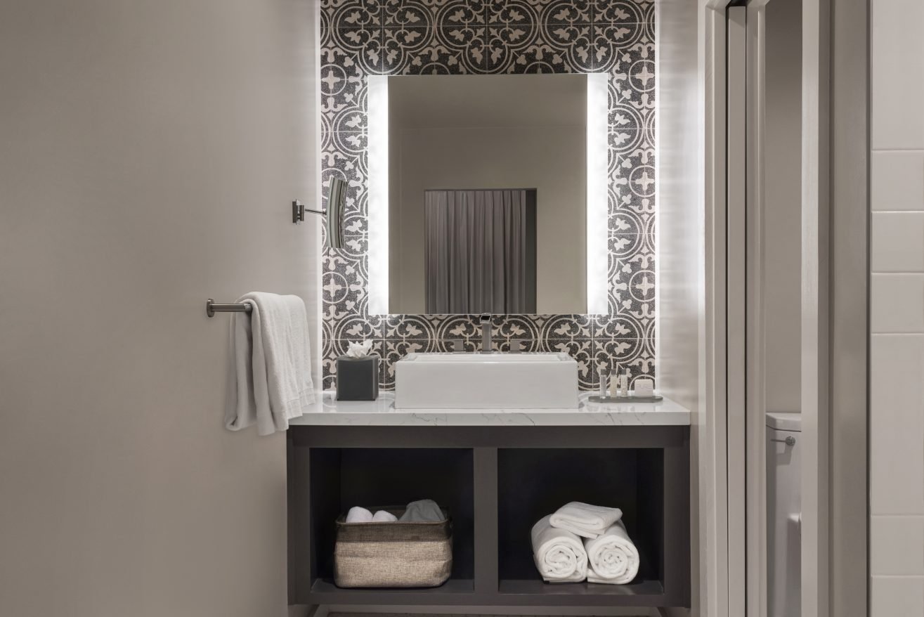 Bathroom Vanity with tiles around the mirror.