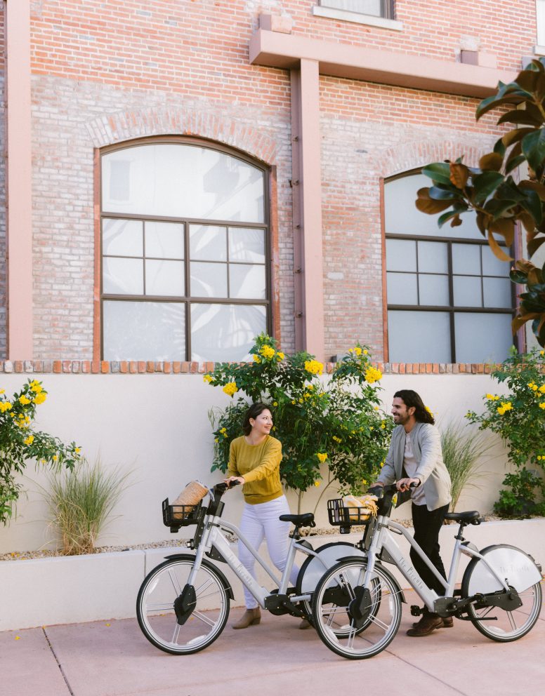 Two people walking next to their Piccolo branded e-bikes.